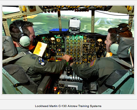 Lockheed Martin C-130 aircrew training simulator cockpit, two crew members at the flight controls.
