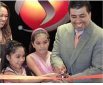 Ribbon-cutting ceremony with Dr. Garcia and family cutting a red ribbon, SimIS logo above.