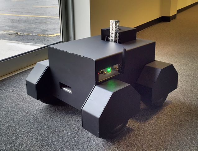 Caliente SimIS RhTT robotic target on four wheels, indoors near a window.