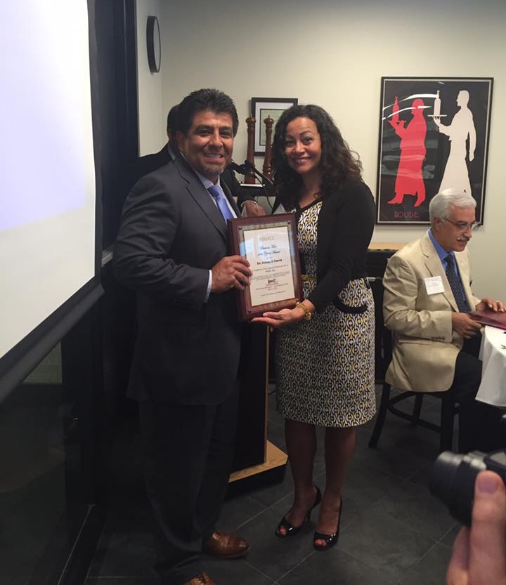 Dr. Johnny Garcia receiving a framed Business Man of the Year Award plaque at the HRHCC awards ceremony.