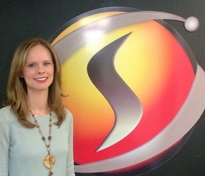 Amber Horton, SimIS Chief Financial Officer, standing in front of the SimIS logo.