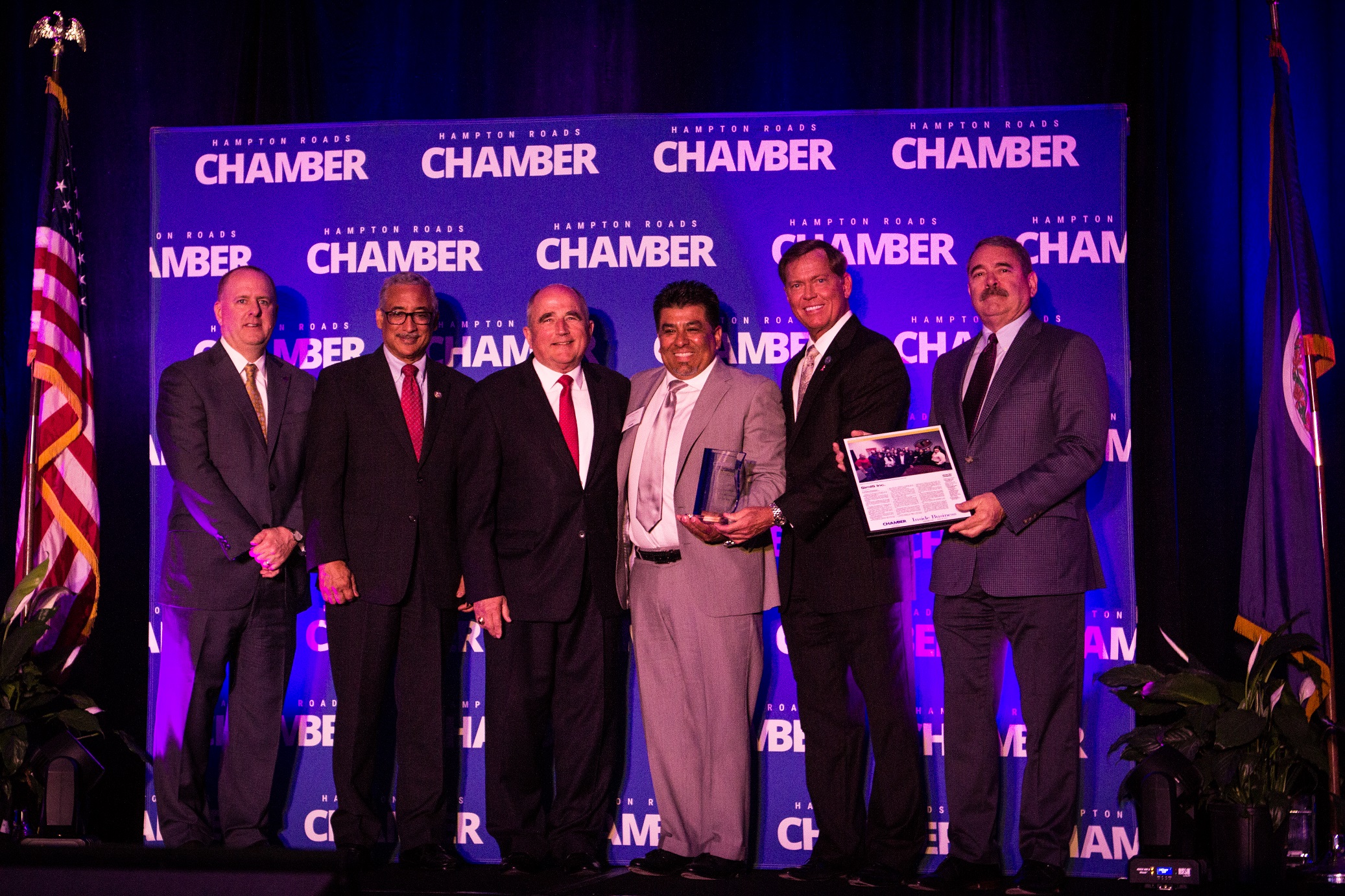 Dr. Johnny Garcia holding the Small Business of the Year trophy alongside Chamber officials at the awards ceremony.
