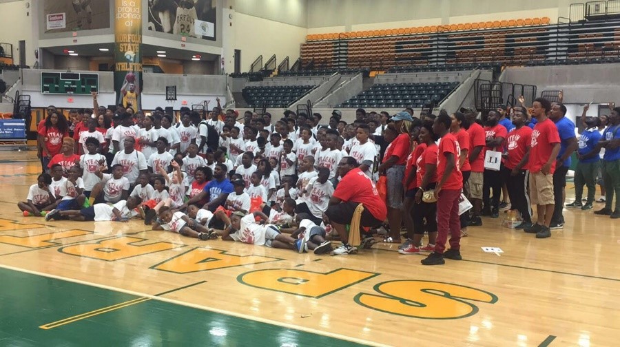 Large group photo of STEAM Camp participants and volunteers gathered on the Norfolk State University basketball court.