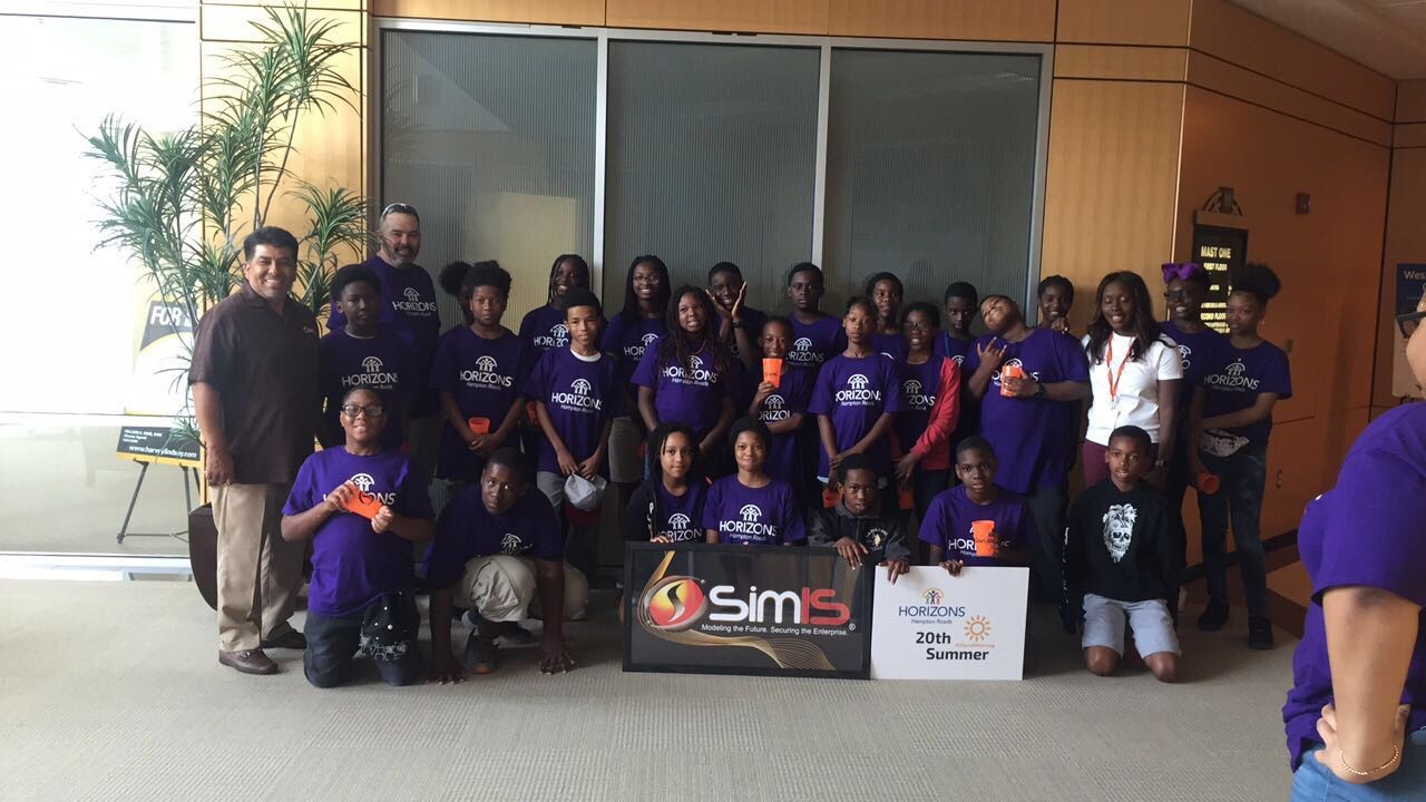 Group photo of Horizons Hampton Roads campers and SimIS staff, holding SimIS and 'Horizons 20th Summer' signs.