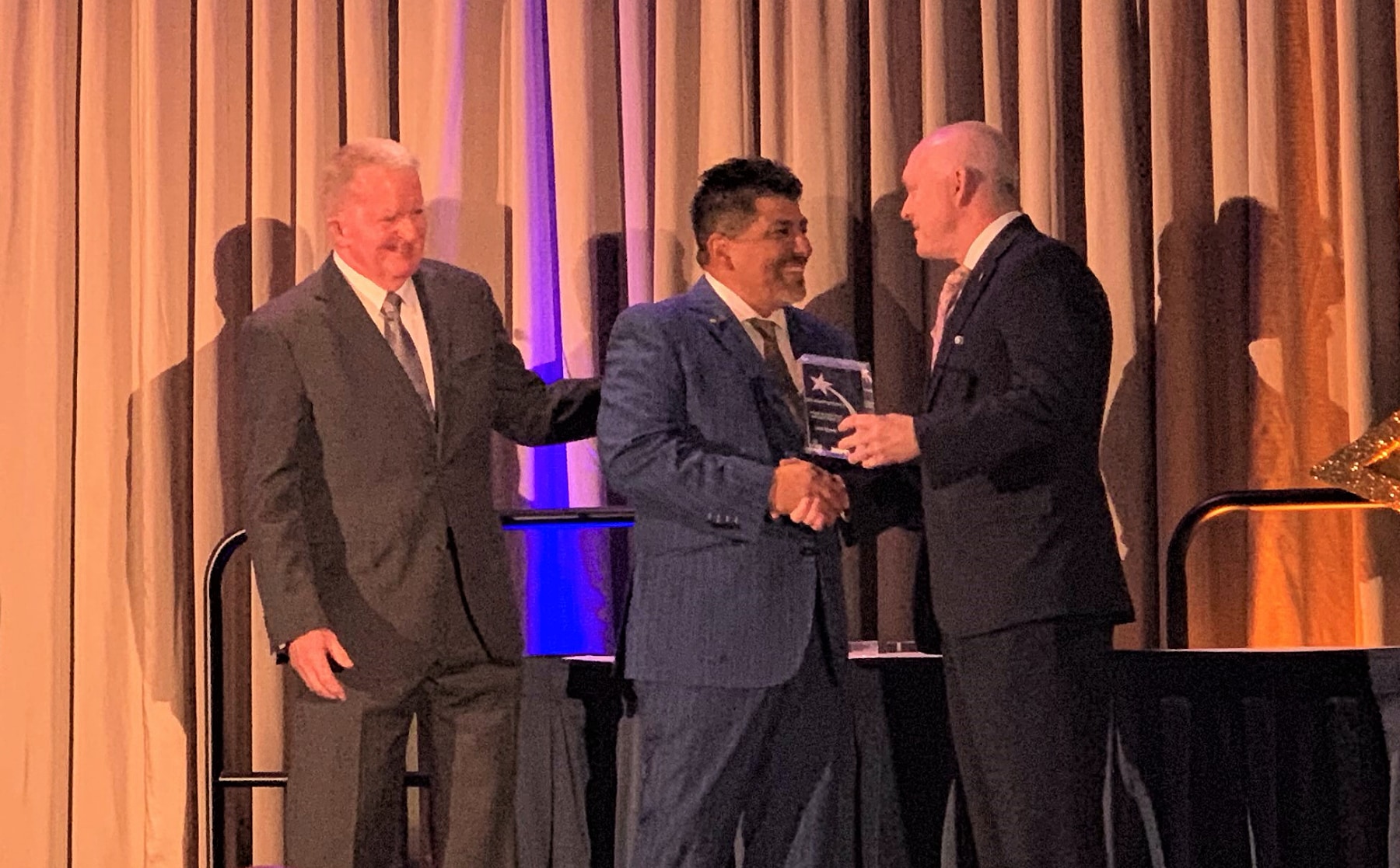 Dr. Johnny Garcia receiving the Small Business Support for STEM Education Award on stage at the Launching Futures Event.